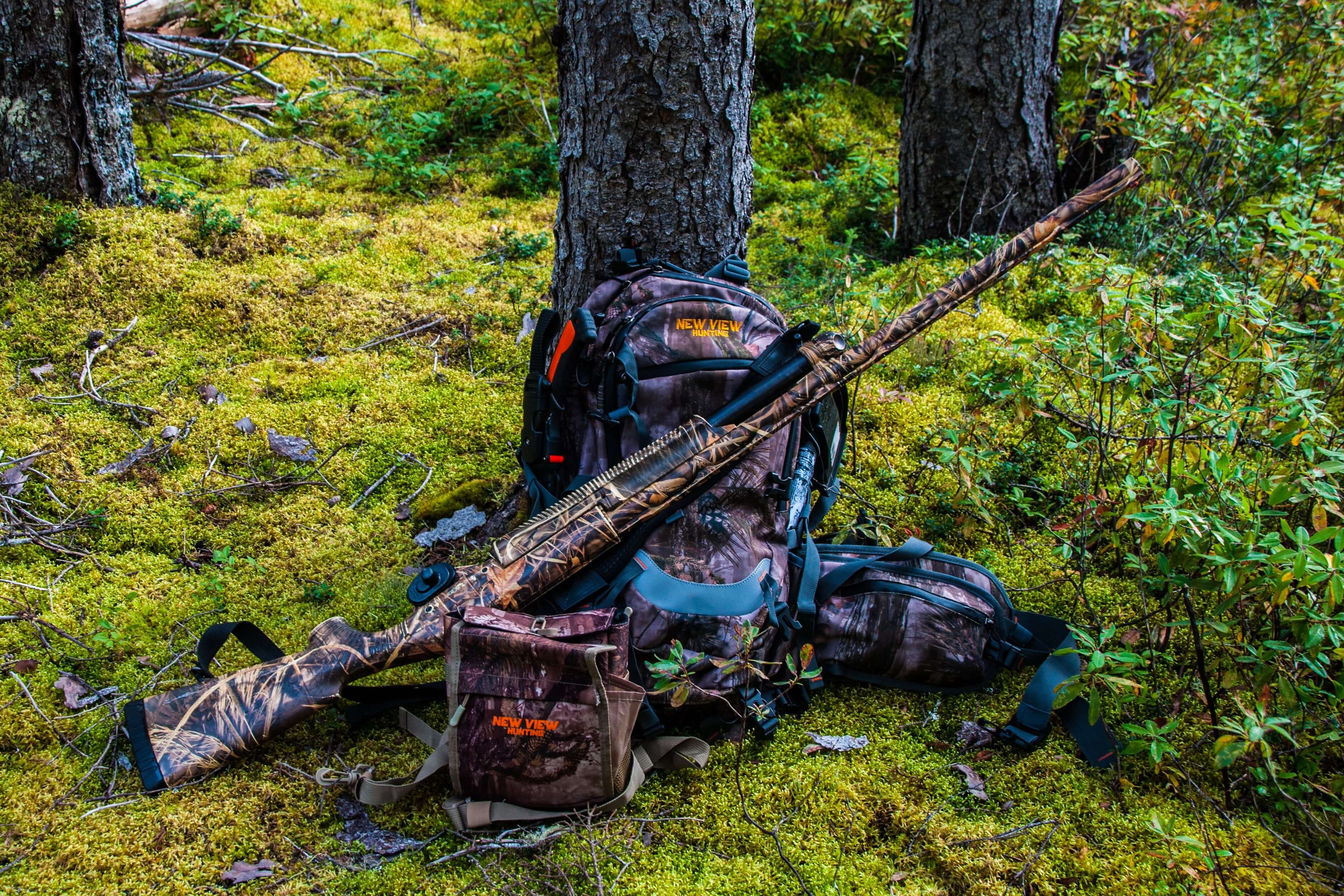 New View Hunting backpack and bino harnesses arranged with hunting gear in woodland