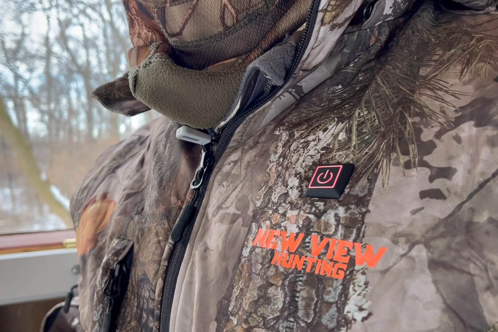 Camouflage heated hunting clothing with illuminated power button and New View Hunting logo