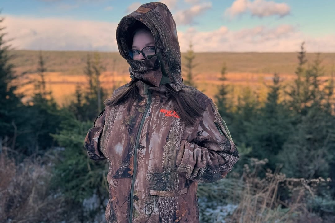Woman wearing camouflage hunting clothing in the field